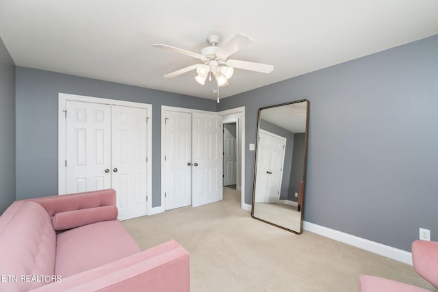 sitting room with ceiling fan and light colored carpet