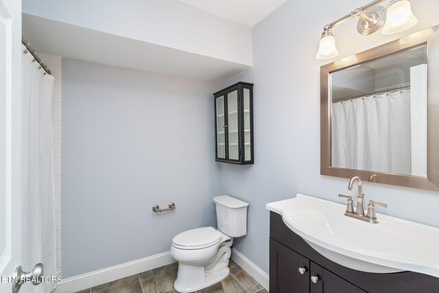 bathroom with curtained shower, vanity, and toilet