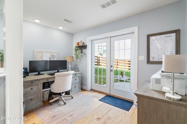 home office with french doors and light hardwood / wood-style floors