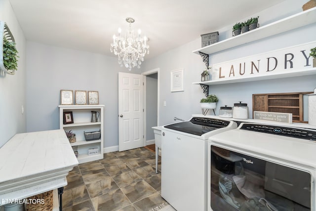 clothes washing area with washing machine and dryer and an inviting chandelier