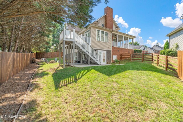 rear view of house with a wooden deck and a lawn