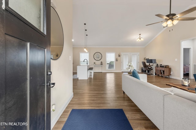 interior space featuring dark hardwood / wood-style floors, sink, vaulted ceiling, ornamental molding, and ceiling fan