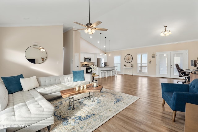 living room featuring french doors, high vaulted ceiling, ceiling fan with notable chandelier, crown molding, and hardwood / wood-style floors