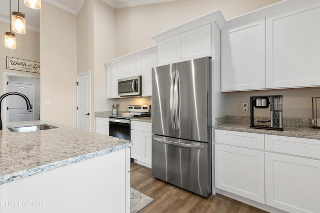 kitchen featuring dark hardwood / wood-style floors, white cabinetry, hanging light fixtures, appliances with stainless steel finishes, and crown molding