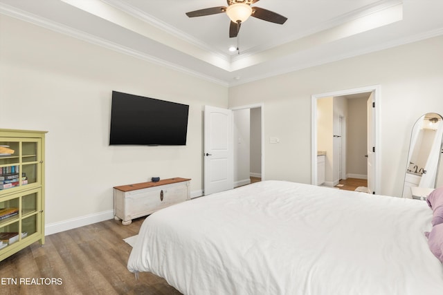 bedroom with a tray ceiling, ornamental molding, ceiling fan, and hardwood / wood-style flooring