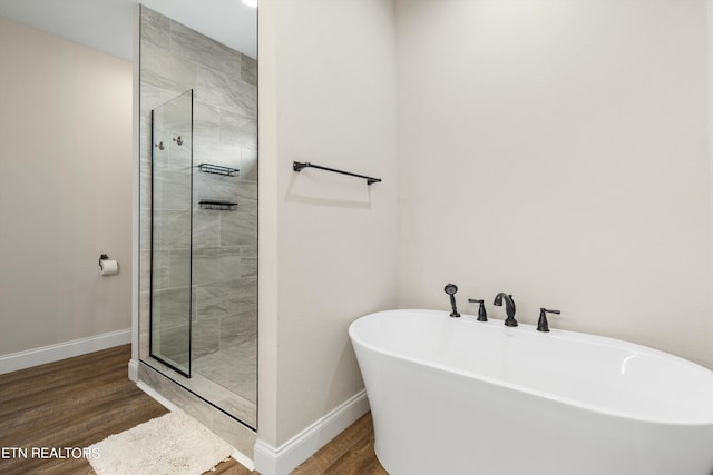 bathroom featuring plus walk in shower and wood-type flooring