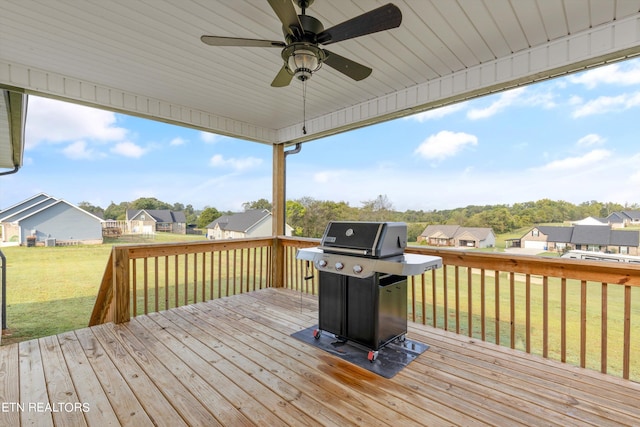 wooden terrace with a yard, ceiling fan, and a grill