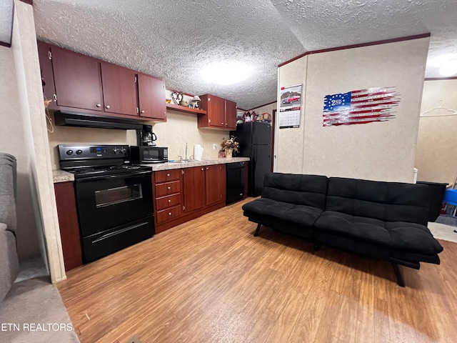 kitchen with vaulted ceiling, a textured ceiling, light hardwood / wood-style floors, and black appliances