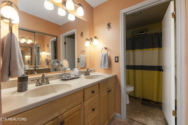 bathroom featuring curtained shower, tile patterned flooring, vanity, and toilet