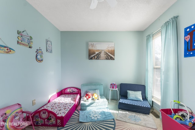 bedroom with ceiling fan and a textured ceiling