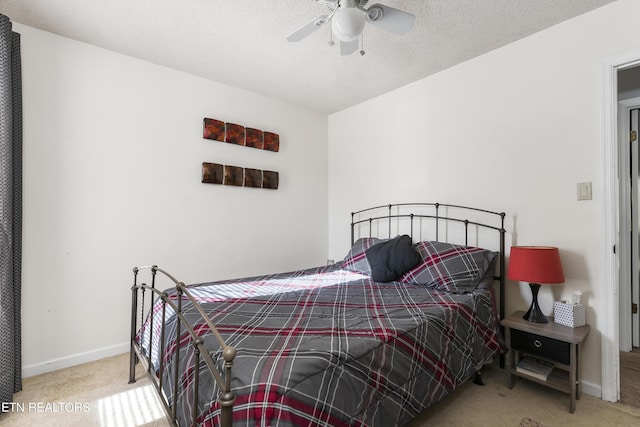 carpeted bedroom with ceiling fan and a textured ceiling