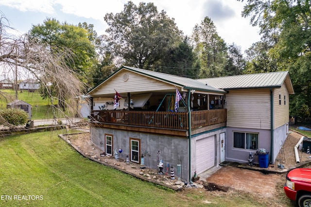 back of property with a garage and a lawn