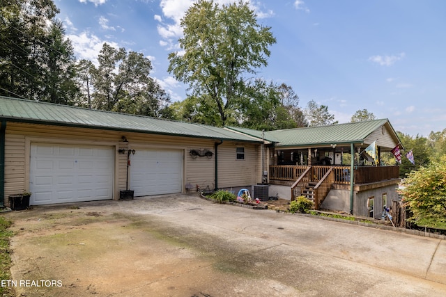 ranch-style house with central AC unit, a porch, and a garage