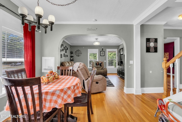 dining space with ornamental molding, a chandelier, and hardwood / wood-style flooring