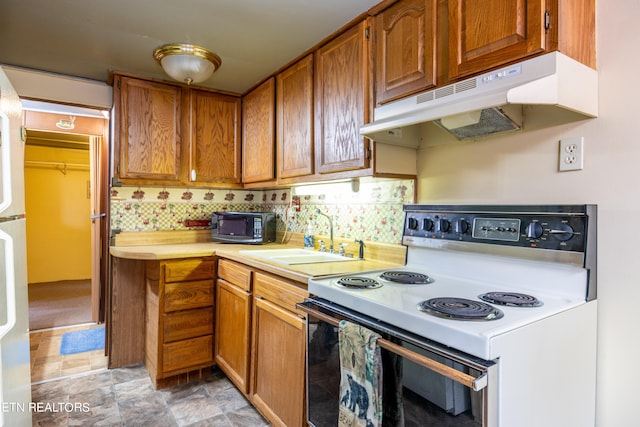 kitchen featuring backsplash, white electric range oven, and sink