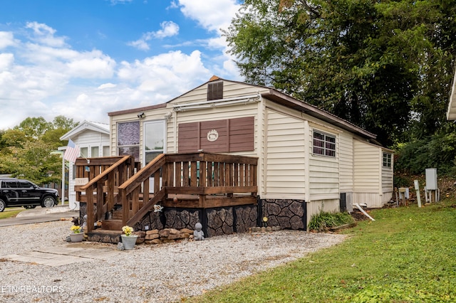 back of house with a lawn and a deck