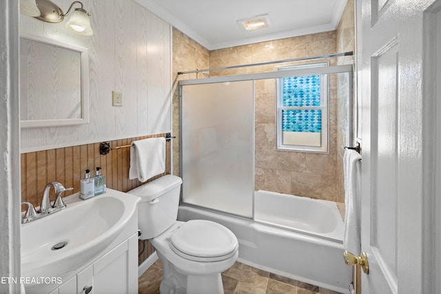 full bathroom featuring toilet, wooden walls, ornamental molding, vanity, and enclosed tub / shower combo