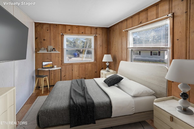 bedroom with wooden walls, crown molding, and dark hardwood / wood-style floors