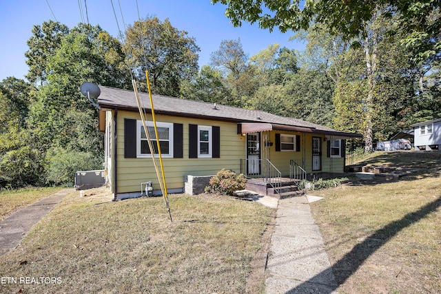 view of front of home with central AC and a front yard