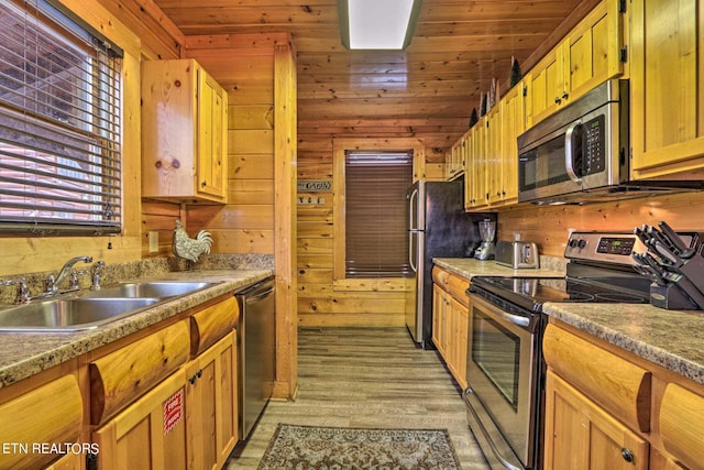 kitchen with wood ceiling, light hardwood / wood-style floors, sink, wooden walls, and appliances with stainless steel finishes