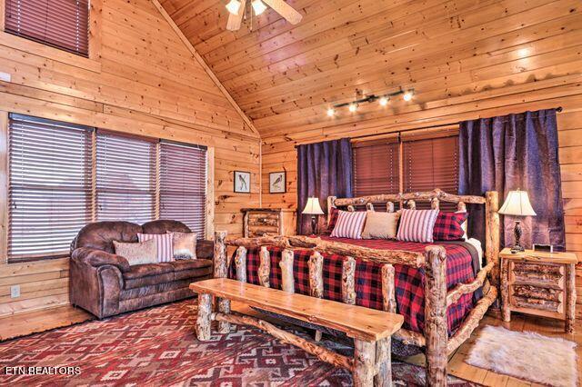 bedroom with wooden ceiling, wood walls, ceiling fan, and high vaulted ceiling