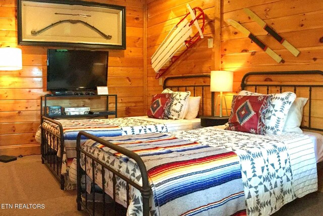 bedroom with carpet flooring and wood walls