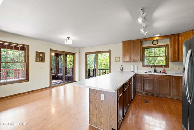 kitchen with light hardwood / wood-style floors, kitchen peninsula, and plenty of natural light