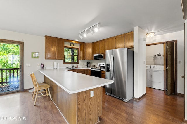 kitchen with a kitchen breakfast bar, stainless steel appliances, kitchen peninsula, and dark wood-type flooring