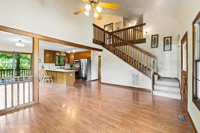 living room with high vaulted ceiling, wood-type flooring, and ceiling fan