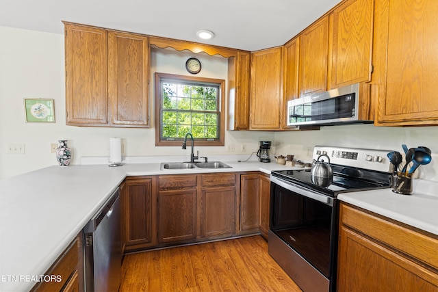 kitchen featuring light hardwood / wood-style floors, stainless steel appliances, and sink