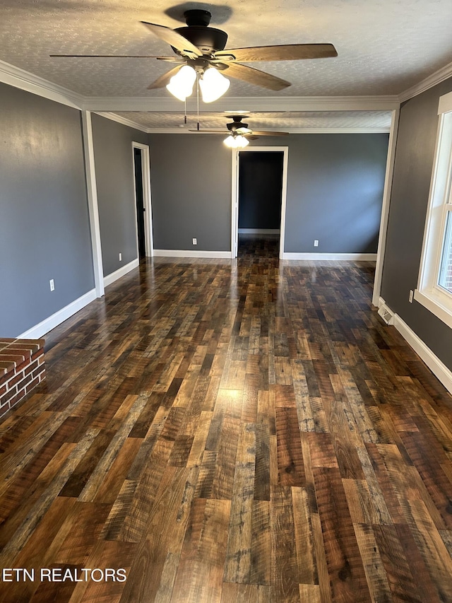 spare room with a textured ceiling, crown molding, dark wood-type flooring, and ceiling fan