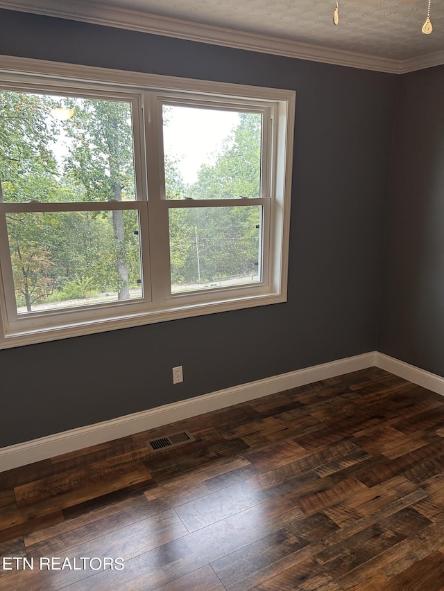 unfurnished room featuring a textured ceiling, plenty of natural light, dark hardwood / wood-style flooring, and crown molding