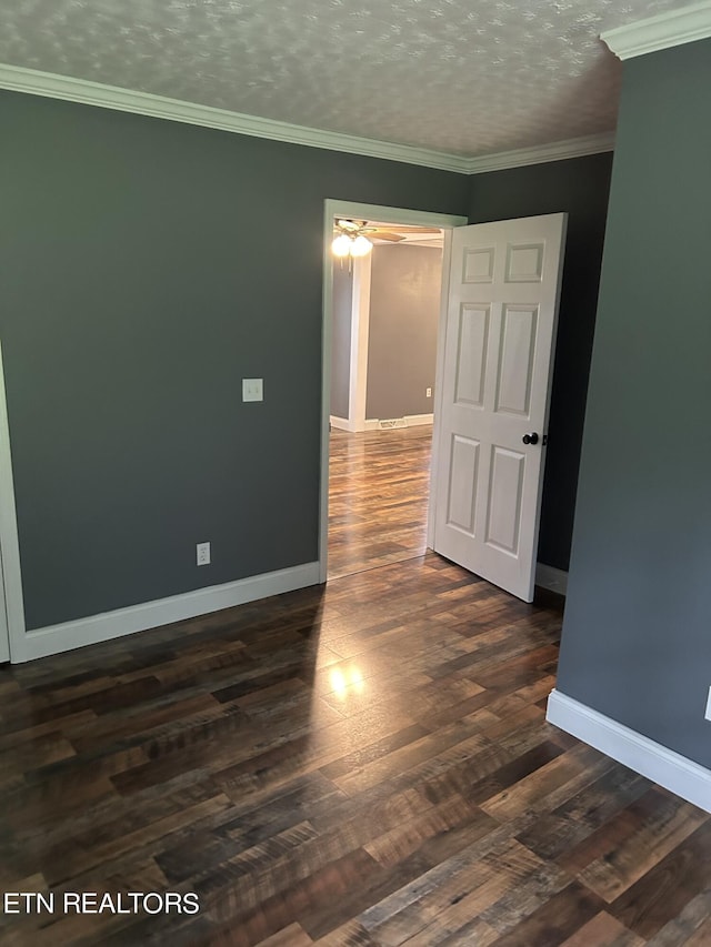 spare room featuring a textured ceiling, crown molding, and dark wood-type flooring