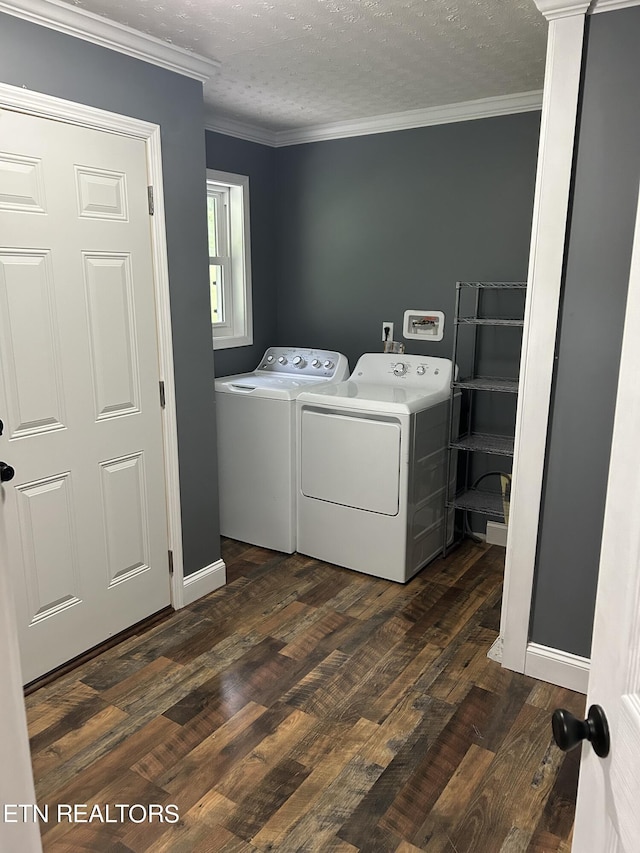 laundry area with a textured ceiling, ornamental molding, dark hardwood / wood-style floors, and washing machine and clothes dryer