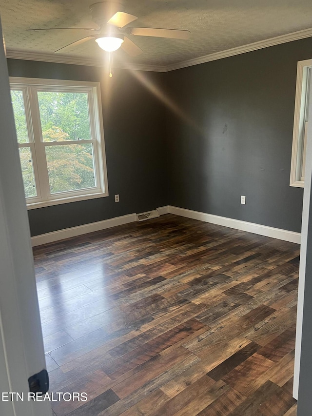 spare room with ceiling fan, crown molding, and dark wood-type flooring