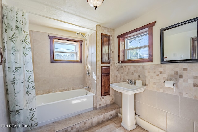 bathroom with tile walls, plenty of natural light, tile patterned flooring, and shower / bath combo