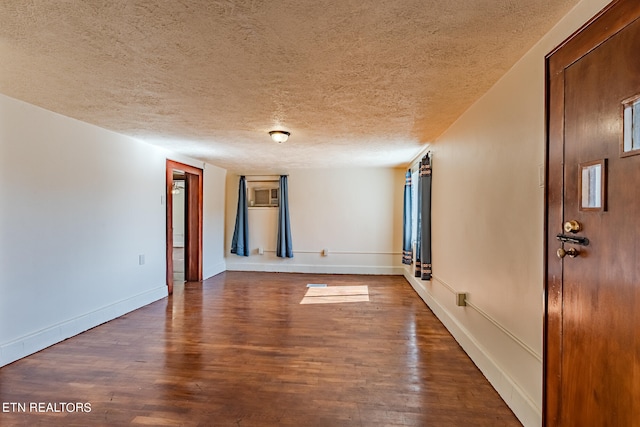 unfurnished room featuring a textured ceiling and dark hardwood / wood-style floors