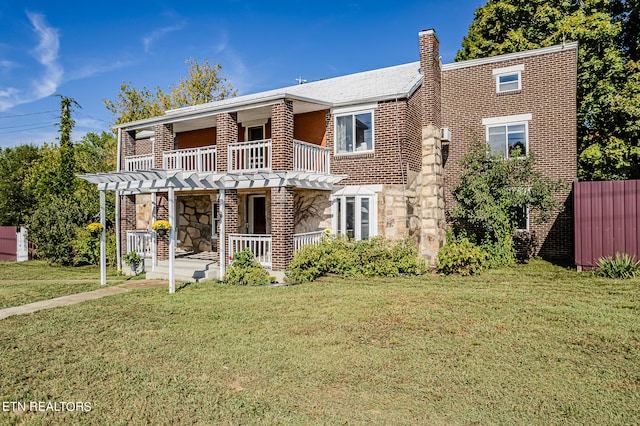 view of front facade with a balcony and a front yard