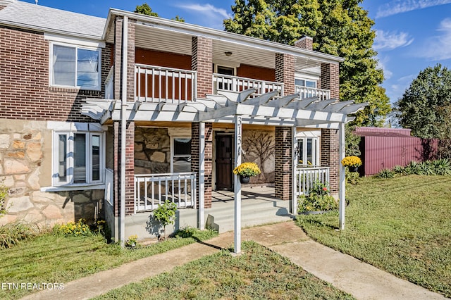 view of front of property with a front yard and a pergola