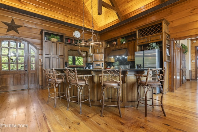 kitchen featuring high vaulted ceiling, kitchen peninsula, light hardwood / wood-style flooring, stainless steel fridge with ice dispenser, and wood ceiling