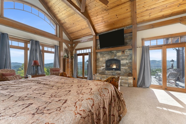 bedroom featuring beam ceiling, a stone fireplace, high vaulted ceiling, carpet floors, and access to outside