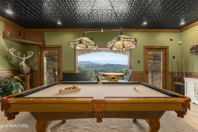 game room with a mountain view, crown molding, and billiards