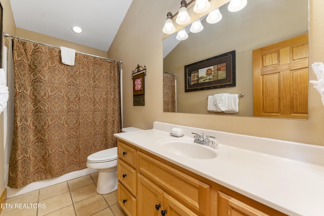 bathroom featuring tile patterned floors, vanity, toilet, and vaulted ceiling