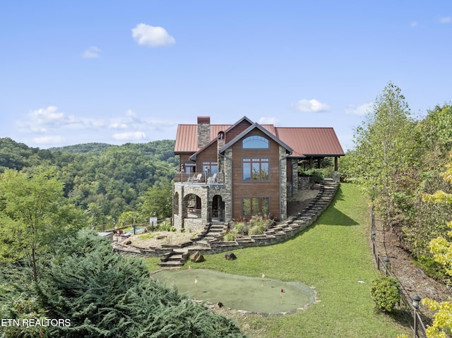 view of front of property featuring a balcony and a front lawn