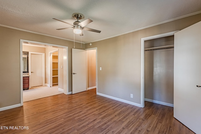 unfurnished bedroom featuring ceiling fan, ornamental molding, a textured ceiling, hardwood / wood-style flooring, and a closet