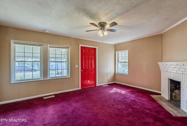 unfurnished living room featuring a textured ceiling, a fireplace, carpet flooring, and ceiling fan