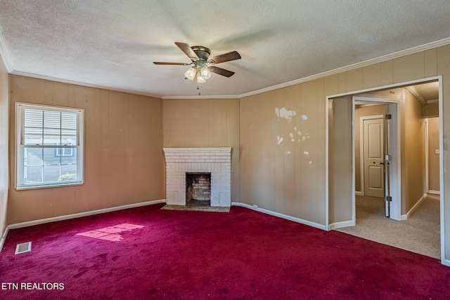 unfurnished living room featuring a textured ceiling, a fireplace, carpet, crown molding, and ceiling fan