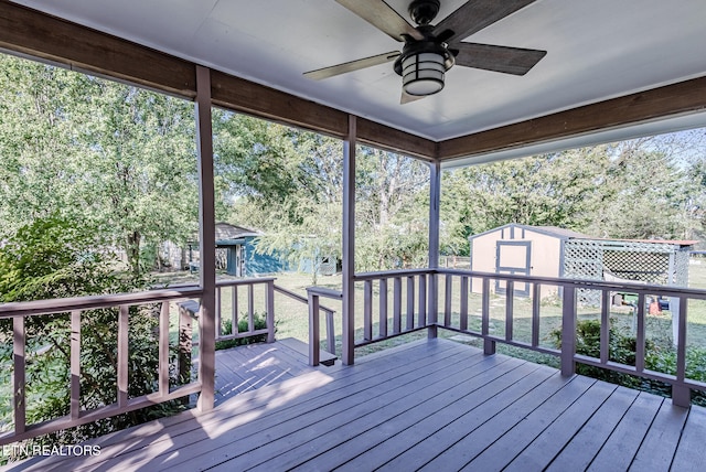 wooden terrace with a storage shed and ceiling fan