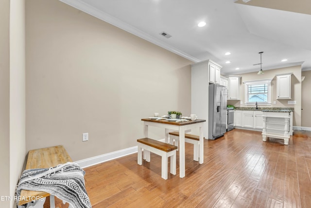 interior space featuring sink, crown molding, and light hardwood / wood-style floors