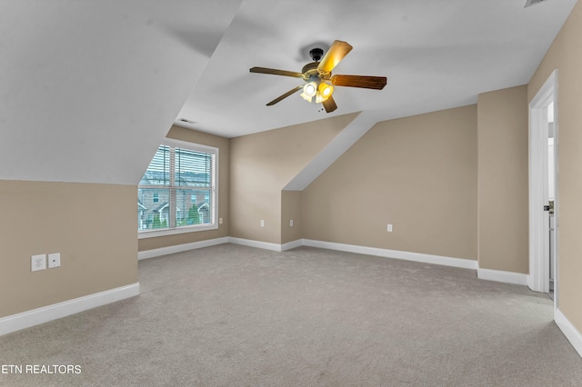 additional living space with lofted ceiling, ceiling fan, and light colored carpet